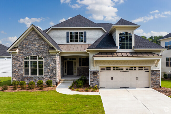 The Green Level community features homes with stone accents and manicured lawns.