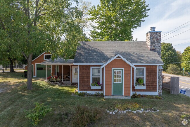 A charming cottage home sits among the trees in Lake Leelanau.