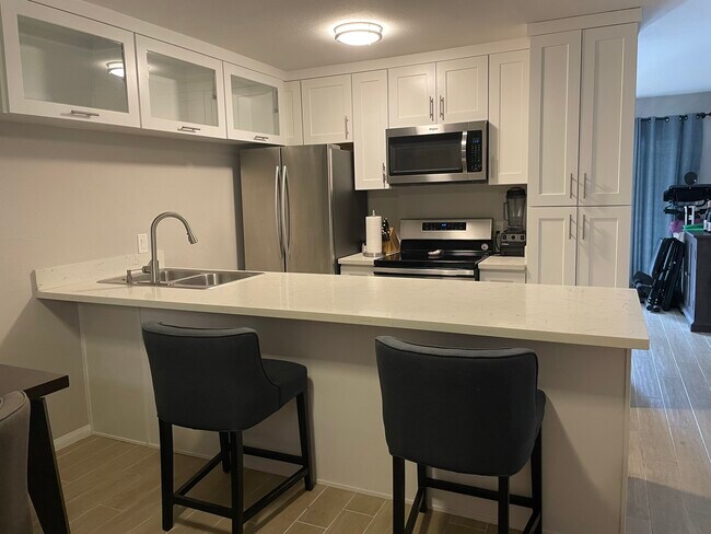 kitchen with large counter, dishwasher, fridge/freezer, oven, stovetop, microwave