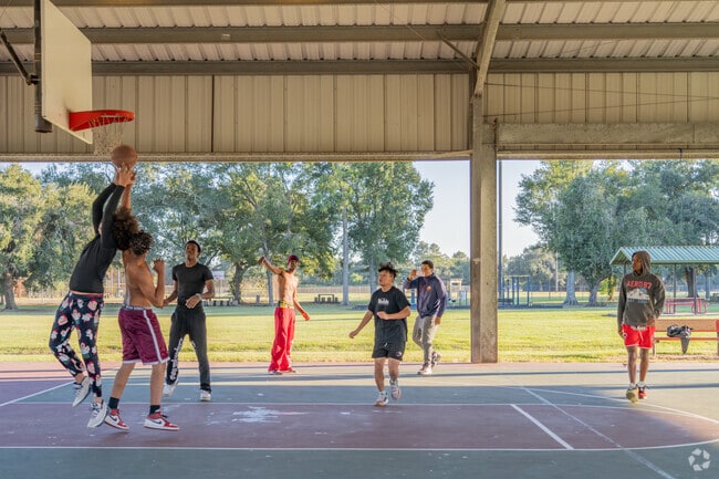 A group of Heymann Park youths catch a game of basketball at a nearby park.