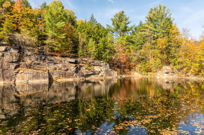 A water-filled quarry in East Barre creates a reflection of the towering cliffs and trees.
