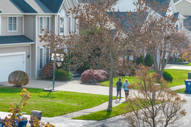 Two friends walk along the sidewalk in the chilly morning in East Amherst, New York.