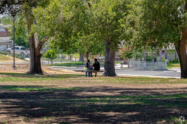 Local residents enjoy the shade from the mature trees at Heritage Park.