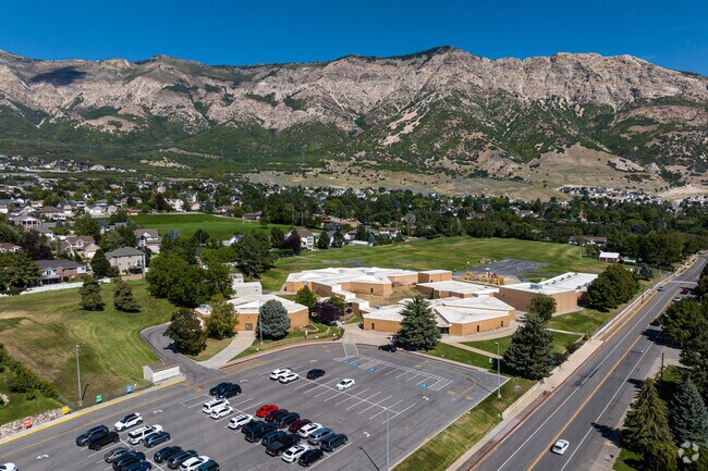 Aerial of Bates Elementary shows a cluster of earth toned buildings as the base of the mountains