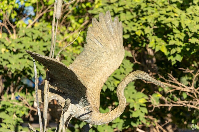 A crane lifting off statue at the entrance of Hudson Crossing Park,  Downtown Oswego.