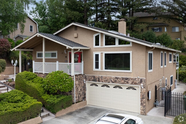 This split-level Contemporary in Glenview Serenity features stonework, large windows, and a bold red door.
