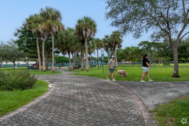 Residents are walking their pets on the walking path at Arvida Park.