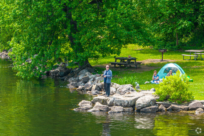 Man fishing with people camping out in Hopatcong State Park.