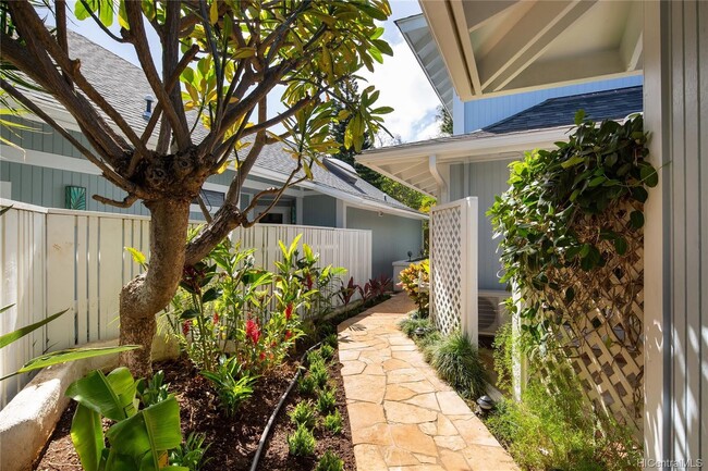 Landscaped entrance with plumeria tree and tropical foliage