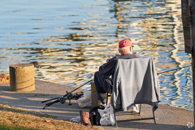 A fisherman relaxes at Rochester Riverfront Park while he waits for the fish to bite.