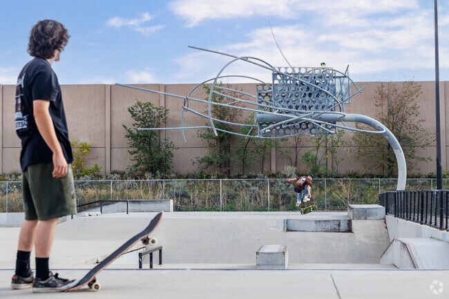 A young man ollies as another watches at Fairmont Skate Park in Sugar House.