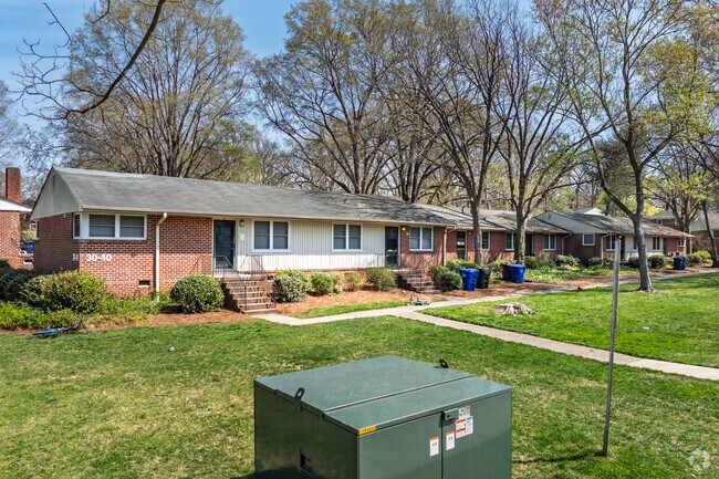 The original brick apartments in Glen Lennox are surrounded by lush green lawns.