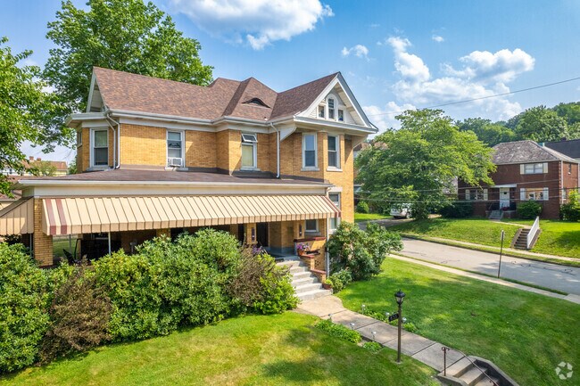 A large home atop a hill in Coraopolis with a wrap around front porch.