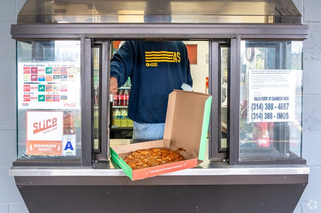 A worker at Imo's Pizza in Castle Park serves up a pizza to go.