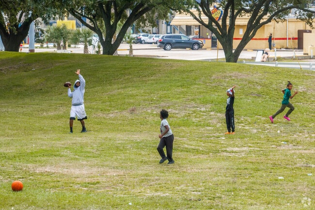 Friends play football on the green space at Goddard Park.
