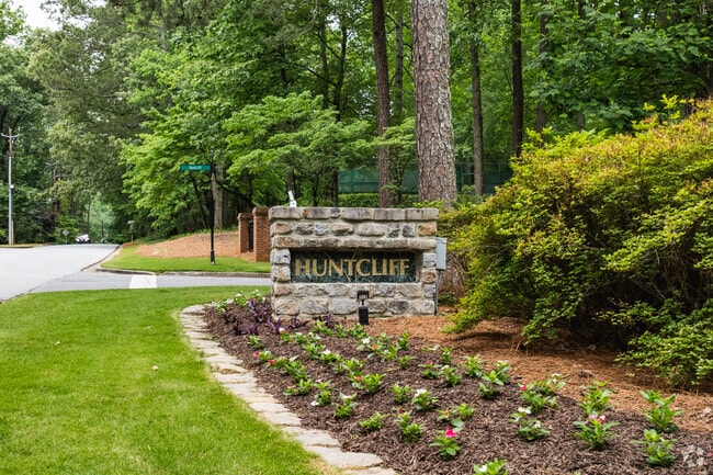 The welcoming stone sign marks the entrance to Huntcliff, a serene Sandy Springs neighborhood known for its wooded charm and upscale homes.