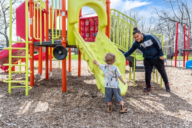 A father and son have a great time playing on the playground at Beulah Park in West Zion.