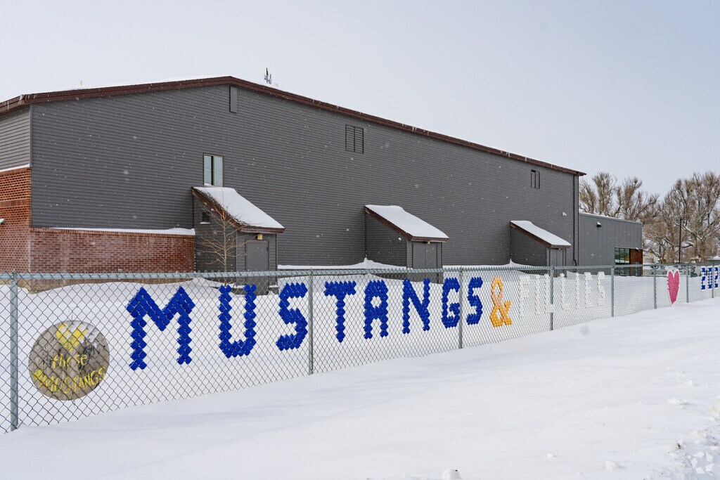 A large fence sign outside Shepherd Elementary School shows the school mascot.