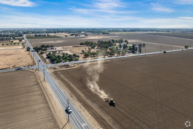 A tractor works the fields, turning the rich soil in preparation for the upcoming season.