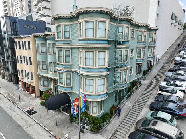 A green victorian building next to a uniquely San Francisco Staircase in Lower Nob Hill.