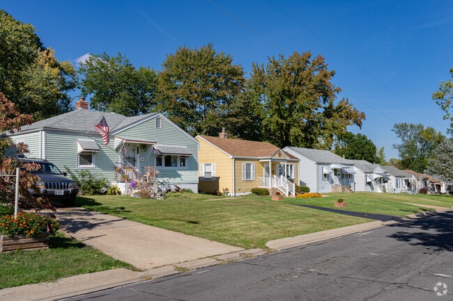 A colorful row of mid-20th-century homes sits on a hill in Saint Ann, Missouri.