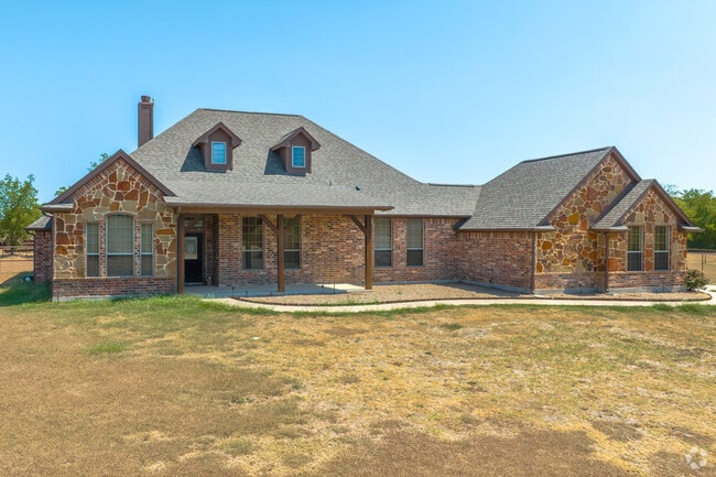 Some homes in Sanger are situated on large lots with a mix of stone and brick exteriors.
