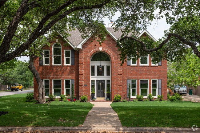 A stunning brick a-frame national style home with great windows in Circle C Ranch.