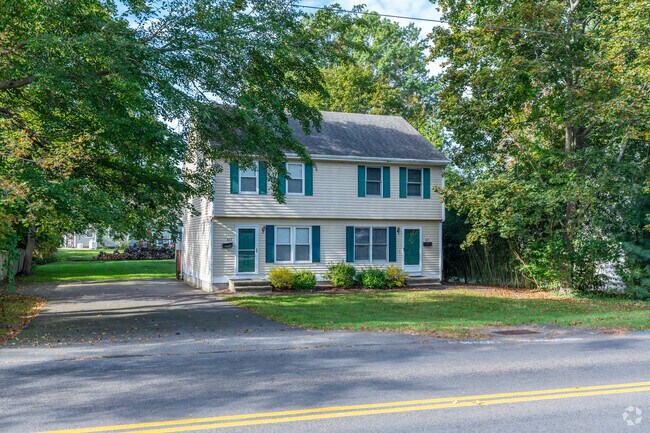Two story home in Guilford with a neat driveway and a calm street in the foreground.