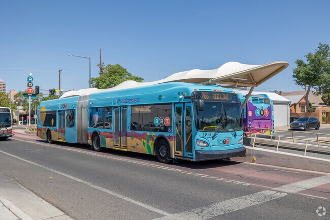 An ART bus waits beneath sleek canopies in Broadway Central Corridor’s transit zone.