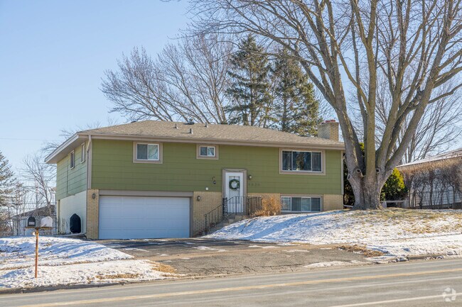 A green split-level house with a brick accent in the Civic Center neighborhood.