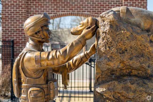 A statue of a veteran petting a dog is at the entrance to Veterans Park. in Minooka, IL.