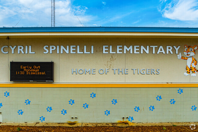 Paw prints line wall of Cyril Spinelli Elementary School.