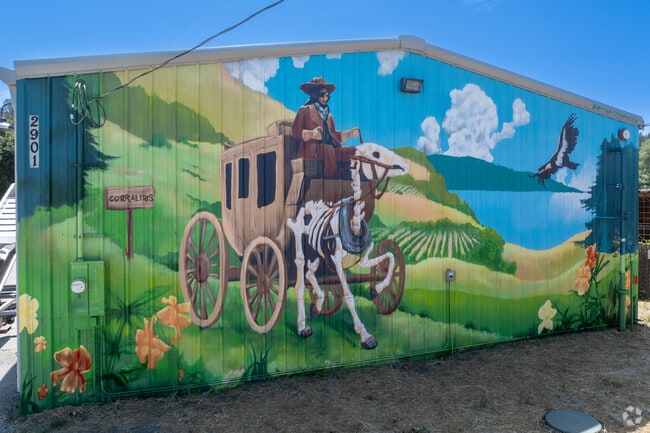 A vivid mural greets visitors to Corralitos, showing a rider in a stagecoach amid fields and coastal hills.