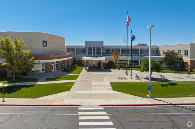 Flags wave against a blue sky at Copper Hills High School.