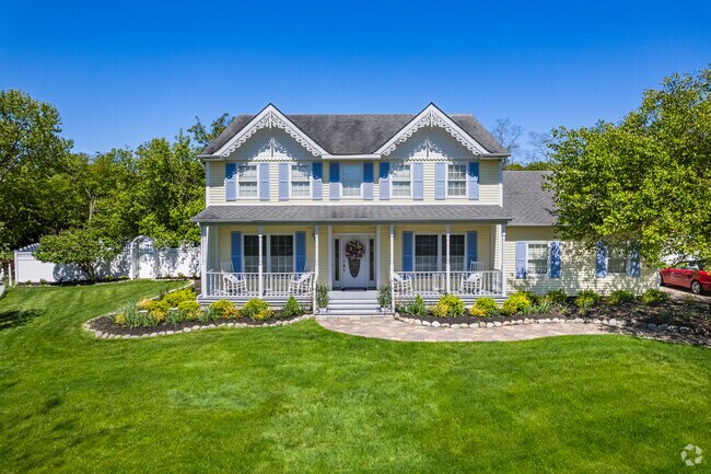 This perfectly manicured Colonial in Stony Brook features exquisite gingerbread moulding.