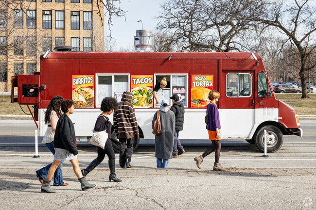 Food trucks outside the Garfield Park Conservatory serve tacos to a busy crowd.
