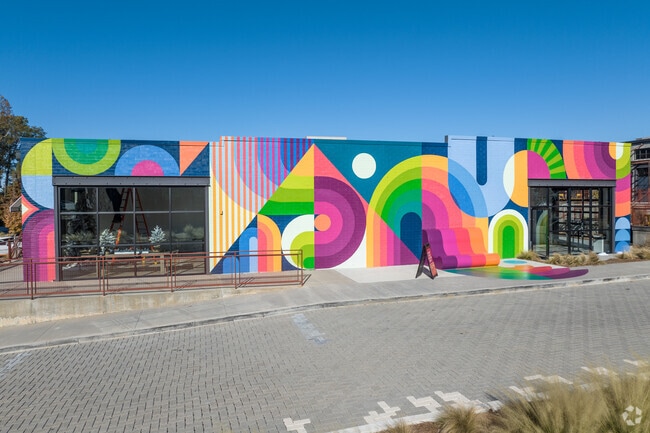 The Works, a mixed-use development center, features colorful buildings near Almond Park.