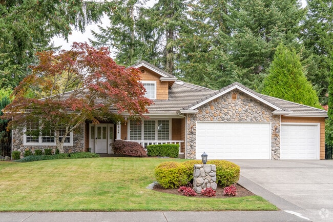 Craftsman home featuring a wide porch, rich wood details, and lush gardens in Indian Summer.