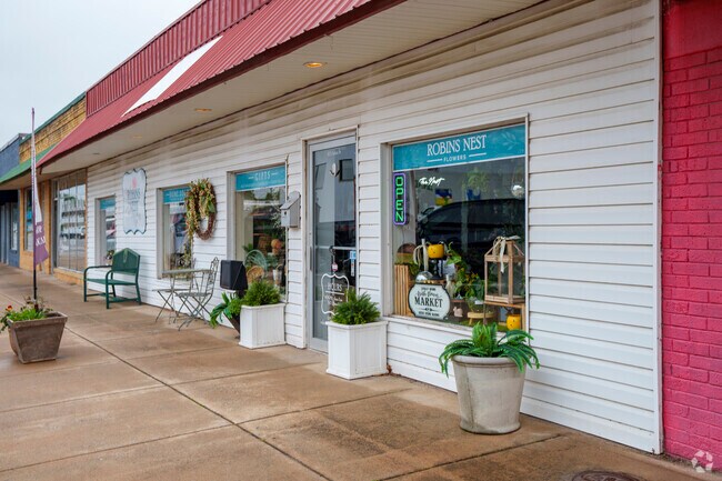 Charming storefronts line the sidewalk of a small retail strip in downtown Pryor Creek.