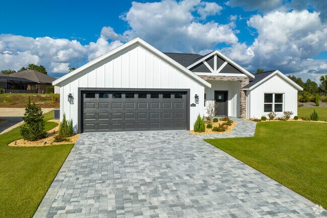 A large modern farmhouse style home sits on manicured lawn in Dunnellon.