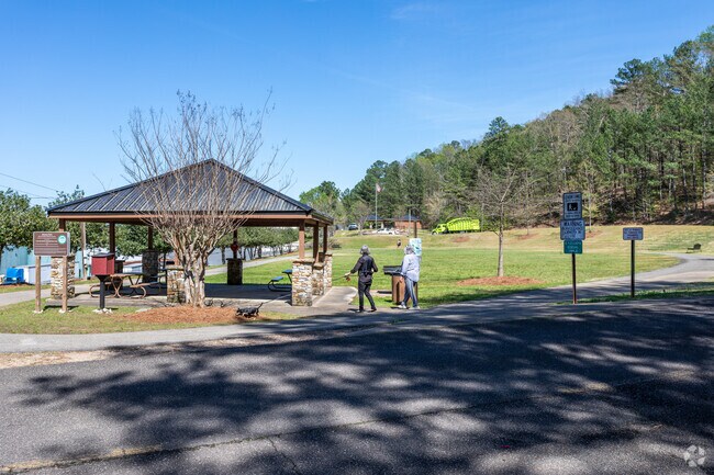 Women walk a dog at Beacon Park, located in Irondale