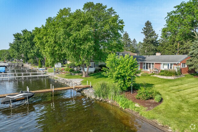 Rows of homes in McHenry Shores are skirting the water front with mature trees for shade.