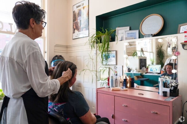 A hairstylist assesses a client's hair at Salon 24 near Maple Avenue District.