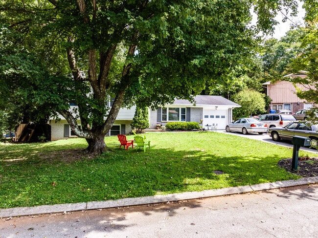 A split-level home with large shade trees in the front yard in Apison.