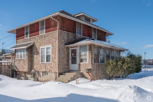 Four-square style stucco house next to Northeast Athletic Fields in Northeast Park.
