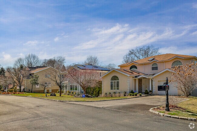 A row of ranch and colonial style home sit tall on a residential street in Ardsley NY.