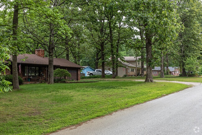 A row of homes among dense trees in the Little Flock neighborhood.
