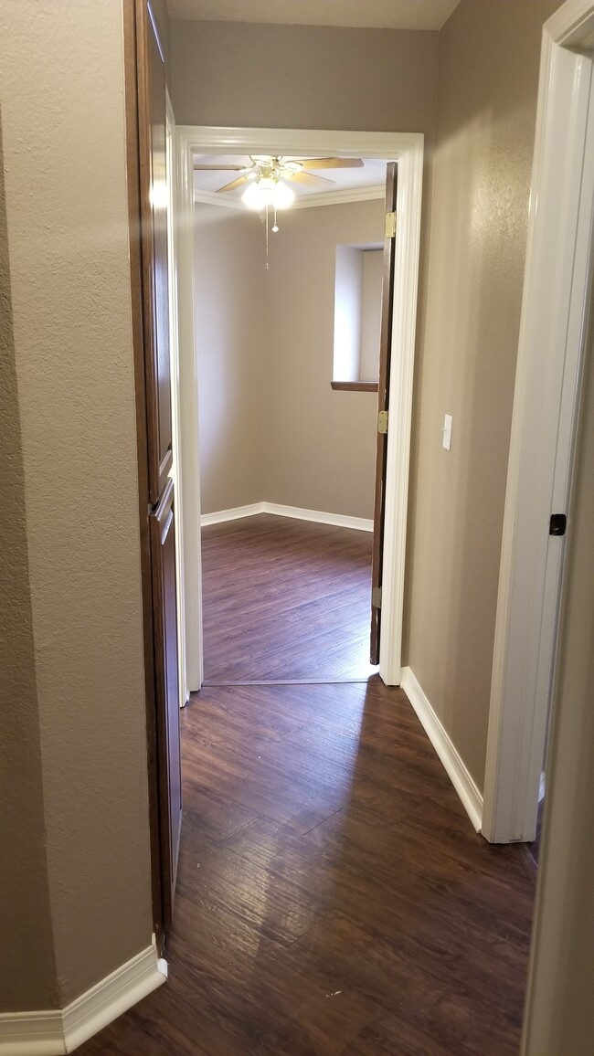 Hallway to 3rd bedroom, storage and restroom on the left