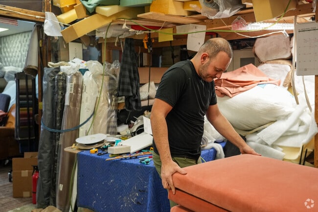 Hakan, the owner of Simply Upholstery & Design renews a piece of furniture in Fairfax Station.