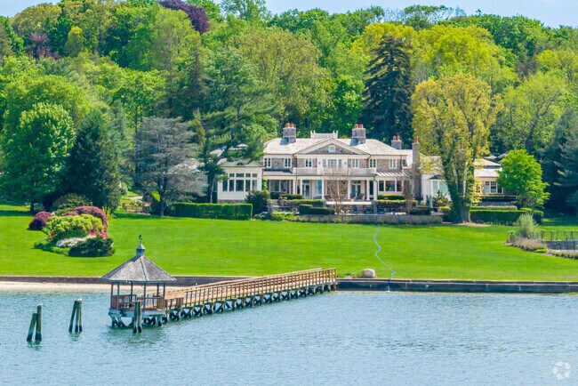 A waterfront estate in Oyster Bay Cove features a private dock with a charming gazebo.